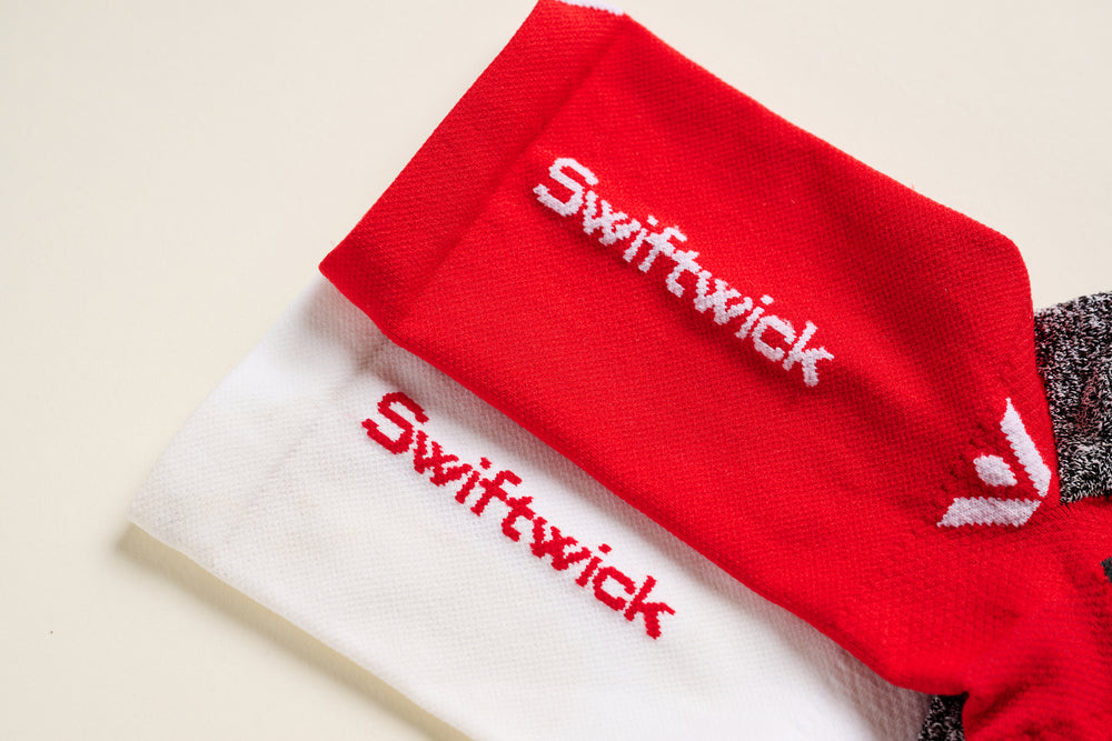 Red and white Swiftwick socks with brand name displayed