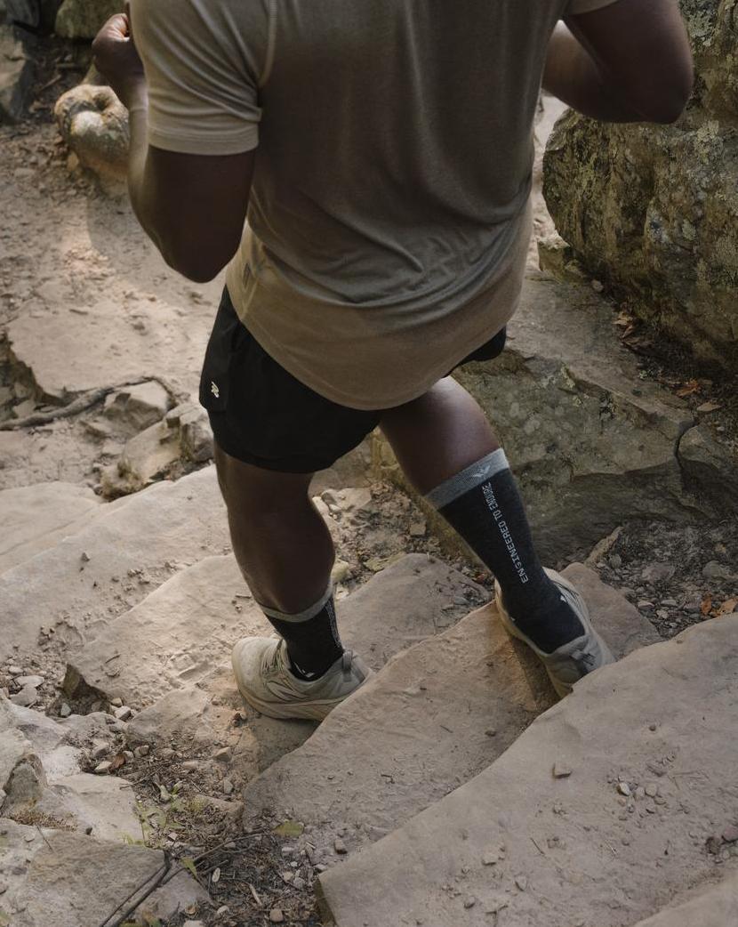 Hiker wearing Pursuit Crew socks while climbing rocky steps